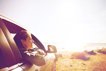 Image showing happy teenage girl or young woman in car