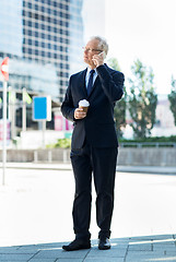 Image showing senior businessman calling on smartphone in city