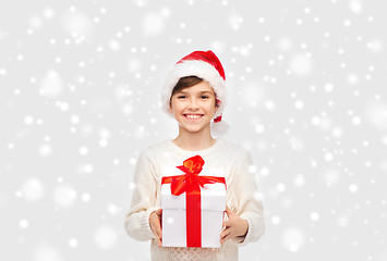 Image showing smiling happy boy in santa hat with gift box