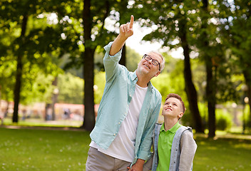 Image showing grandfather and boy pointing up at summer park