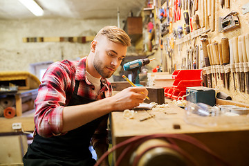 Image showing carpenter writing to notebook at workshop