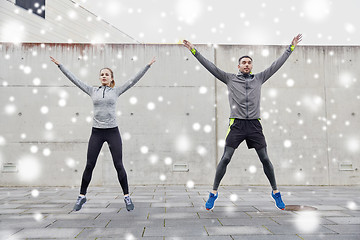 Image showing happy man and woman jumping outdoors