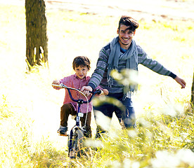 Image showing father learning his son to ride on bicycle outside, real happy f