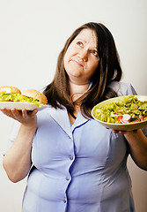 Image showing fat white woman having choice between hamburger and salad close 