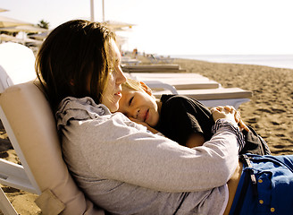 Image showing young mother with son resting on sea coast, happy family togethe