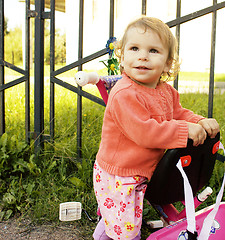 Image showing little girl with mother outside walking on playground, riding bi