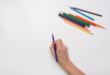 Image showing Woman\'s hand draws a pencil on paper, close-up, top view