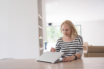 Image showing Young woman with laptop at home