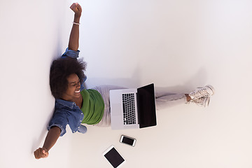 Image showing african american woman sitting on floor with laptop top view