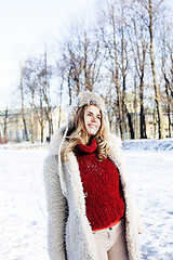 Image showing young pretty teenage hipster girl outdoor in winter snow park having fun drinking coffee, warming up happy smiling, lifestyle people concept