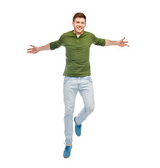 Image showing smiling young man jumping in air