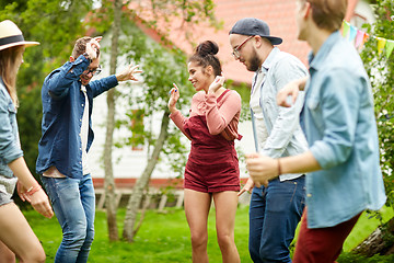 Image showing happy friends dancing at summer party in garden