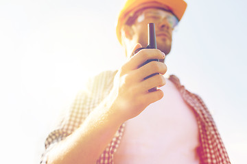 Image showing close up of builder in hardhat with walkie talkie