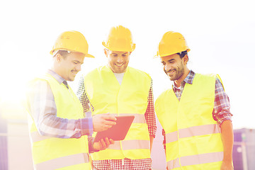 Image showing smiling builders in hardhats with tablet pc