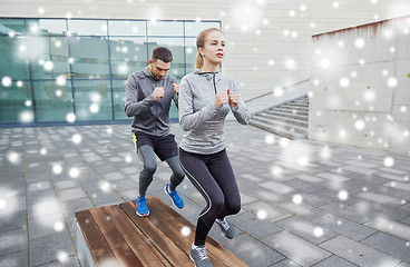 Image showing couple of sportsmen making step exercise on bench