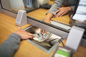 Image showing clerk giving cash money to customer at bank office