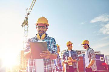 Image showing builder in hardhat with tablet pc at construction