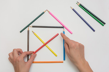 Image showing Female hands corrected pencils, making one wooden house