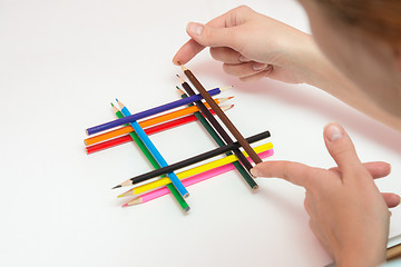 Image showing She builds the pinnacle of pencils on a sheet of white paper