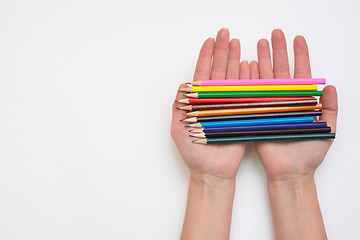 Image showing Female hand holding in his hands a dozen pencils, hands right, left an empty space under the title