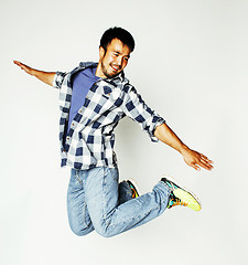 Image showing young pretty asian man jumping cheerful against white background