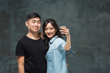 Image showing Portrait of smiling Korean couple on a gray