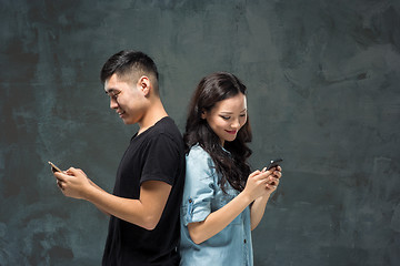 Image showing Asian young couple using cellphone, closeup portrait.