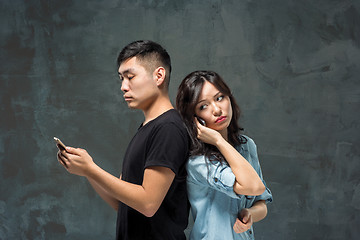 Image showing Asian young couple using cellphone, closeup portrait.