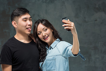 Image showing Portrait of smiling Korean couple on a gray