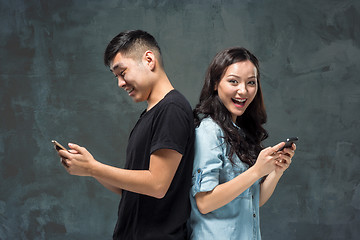 Image showing Asian young couple using cellphone, closeup portrait.