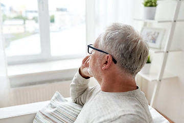 Image showing senior man in glasses thinking at home