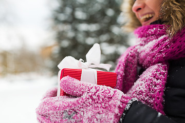 Image showing close up of woman with christmas gift outdoors