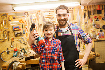 Image showing father and son with drill working at workshop