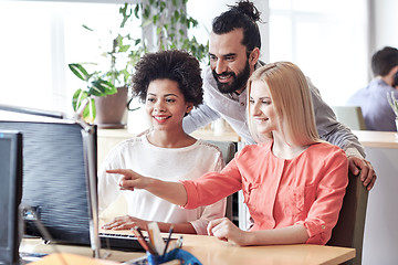 Image showing happy creative team with computer in office