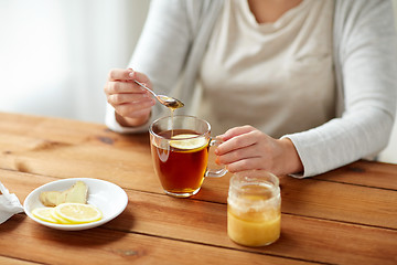 Image showing close up of ill woman drinking tea with lemon