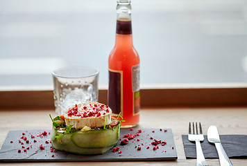 Image showing salad, bottle of drink, glass and cutlery on table