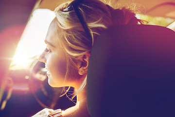 Image showing happy teenage girl or young woman in car