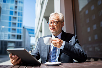 Image showing senior businessman with tablet pc drinking coffee