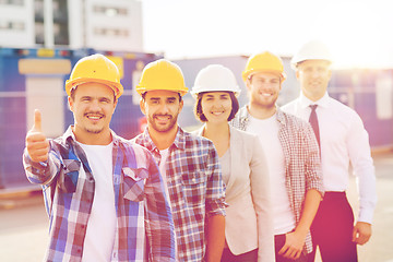 Image showing group of smiling builders in hardhats outdoors