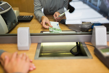 Image showing clerk giving cash money to customer at bank office