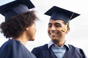 Image showing happy students or bachelors in mortar boards