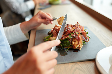 Image showing woman eating prosciutto ham salad at restaurant