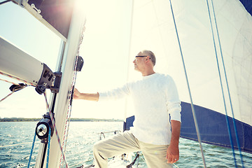 Image showing senior man on sail boat or yacht sailing in sea