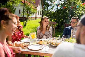 Image showing happy friends having dinner at summer garden party