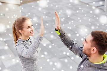 Image showing couple of sportsmen making high five outdoors