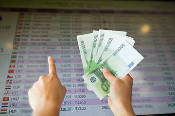 Image showing hands with euro money over currency exchange rates