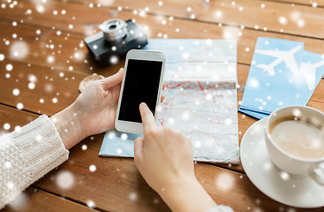 Image showing close up of traveler hands with smartphone and map