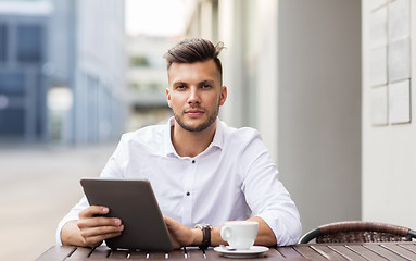 Image showing man with tablet pc and coffee at city cafe