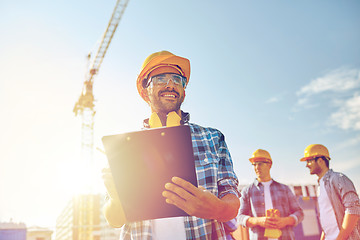 Image showing builder in hardhat with clipboard at construction