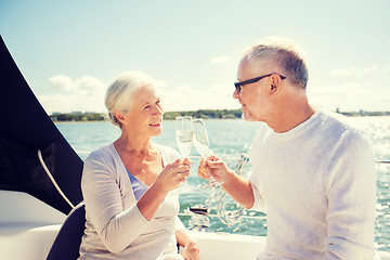 Image showing senior couple clinking glasses on boat or yacht